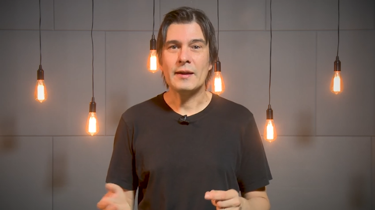 A person standing in front of a wall with light bulbs

Description automatically generated